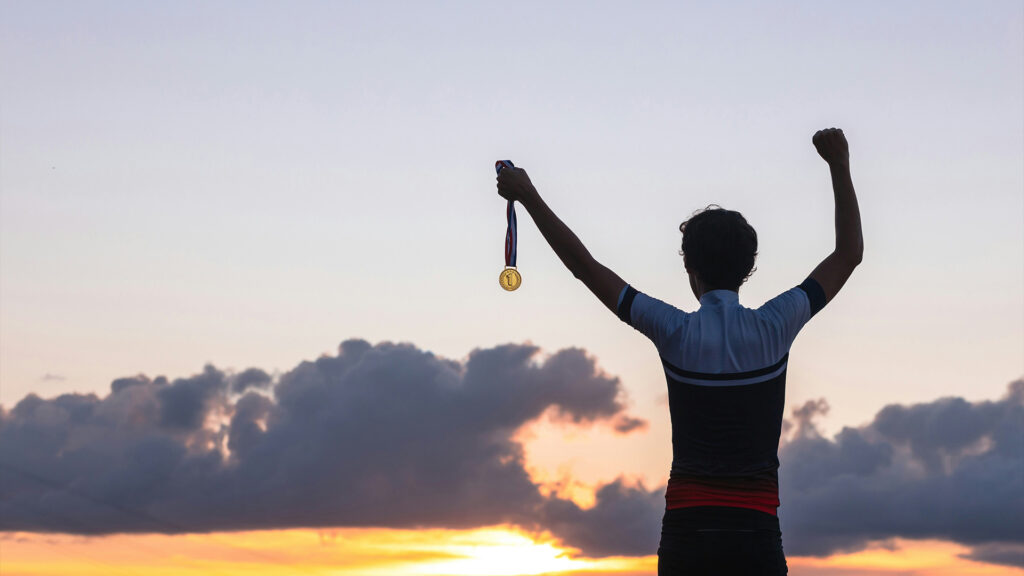 Ein Sportler hat eine Medaille in der Hand 